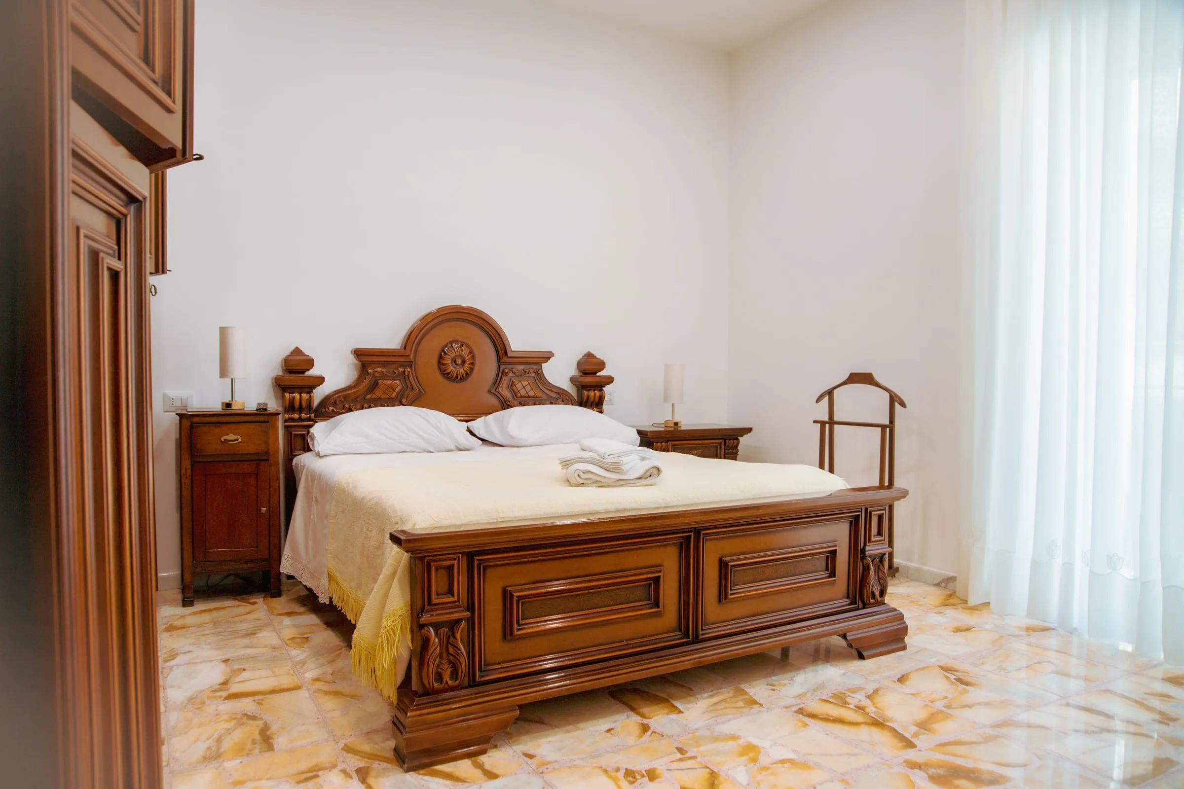 Camera Maria: letto matrimoniale in noce intagliato e pavimento alla palladiana
